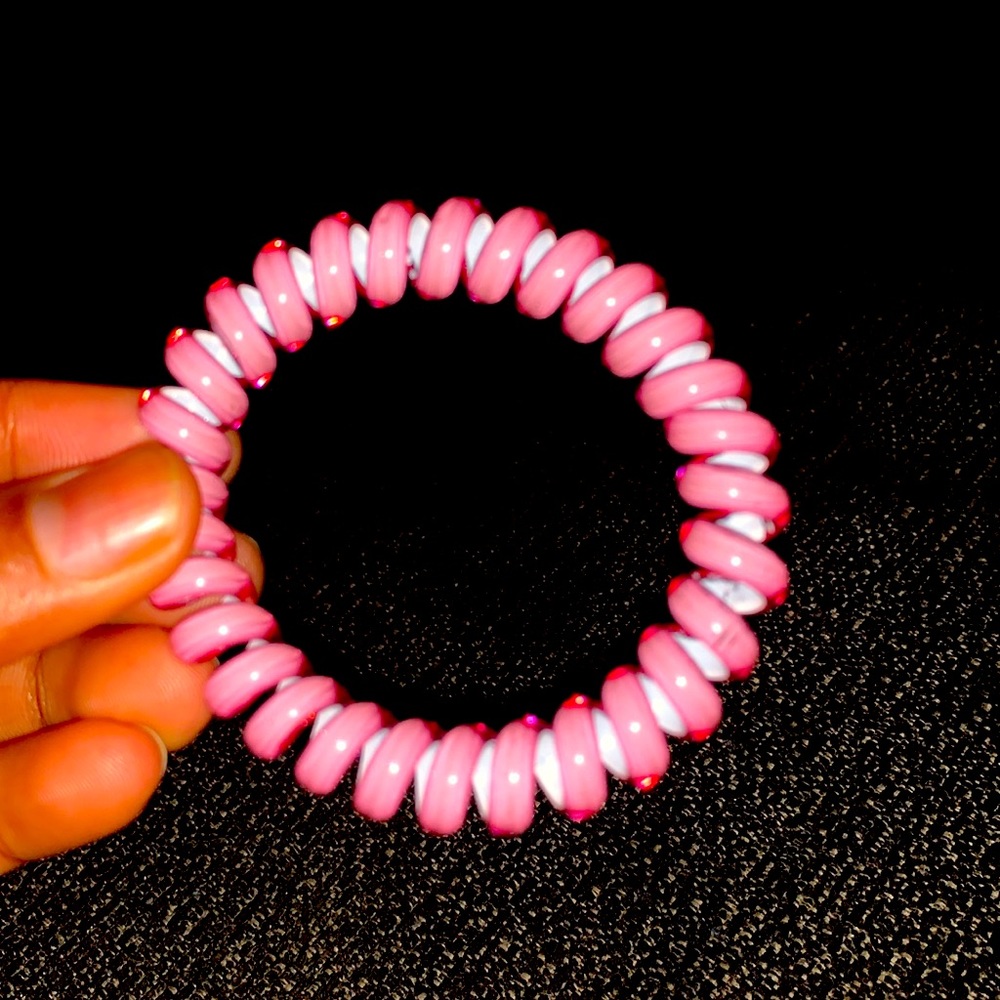 A pink bracelet which is curly and swirly